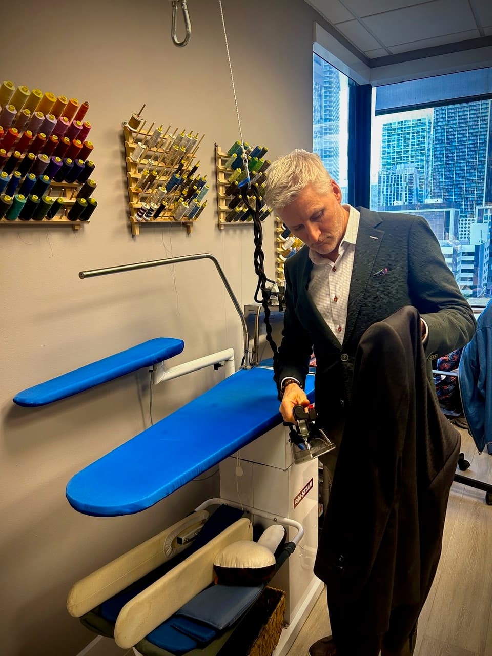 Christian Boehm pressing a finished garment in the tailor shop