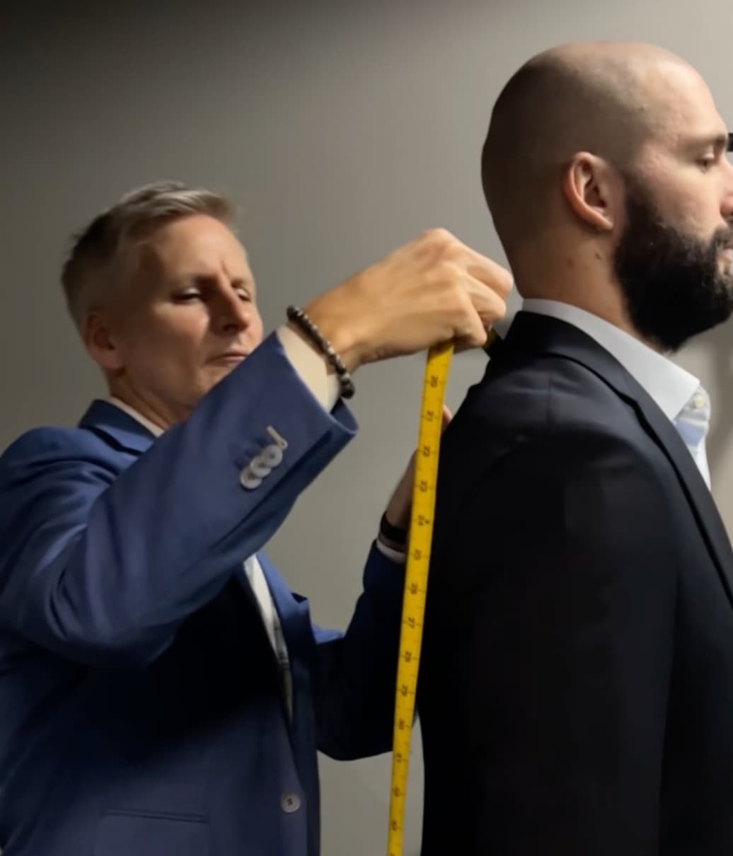 Christian Boehm taking a client’s back measurement with a tape